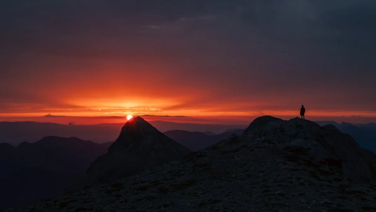 Vīrietis pie sporta auto uz ledus trases Somijā ar ziemeļblāzmu debesīs Vīrietis pie sporta auto uz ledus trases Somijā ar ziemeļblāzmu debesīs