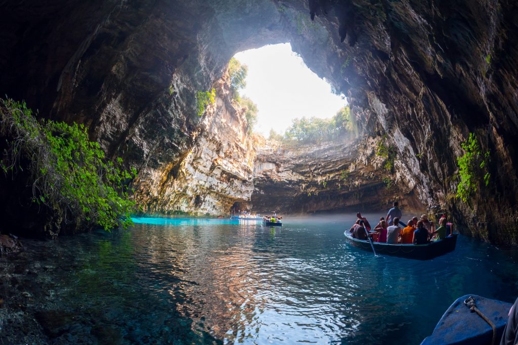 Kefalonia, Greece - August 11, 2015: Melissani is a cave on the island of Kefalonia and is located just outside Sami. Rowboats lead tourists inside the cave, to admire the stalactites and the incredible color-changing water.